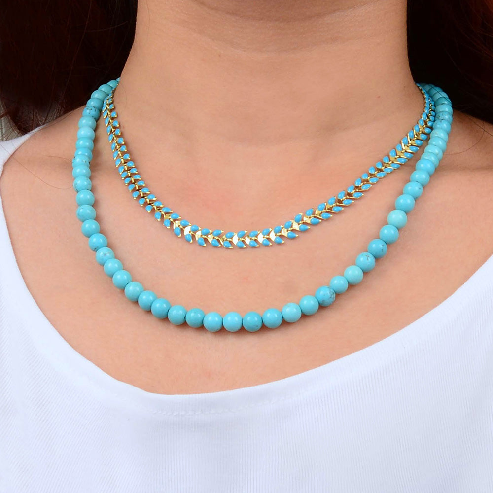 Blue turquoise magnesite layers with golden chevron necklace by Start2Finish, featuring multiple layered stones and a gold-tone chevron pendant.
