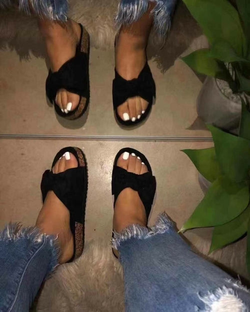 Black women’s slide sandals with a single strap and bow detail by Silver Juneberry, featuring comfortable slip-on design.