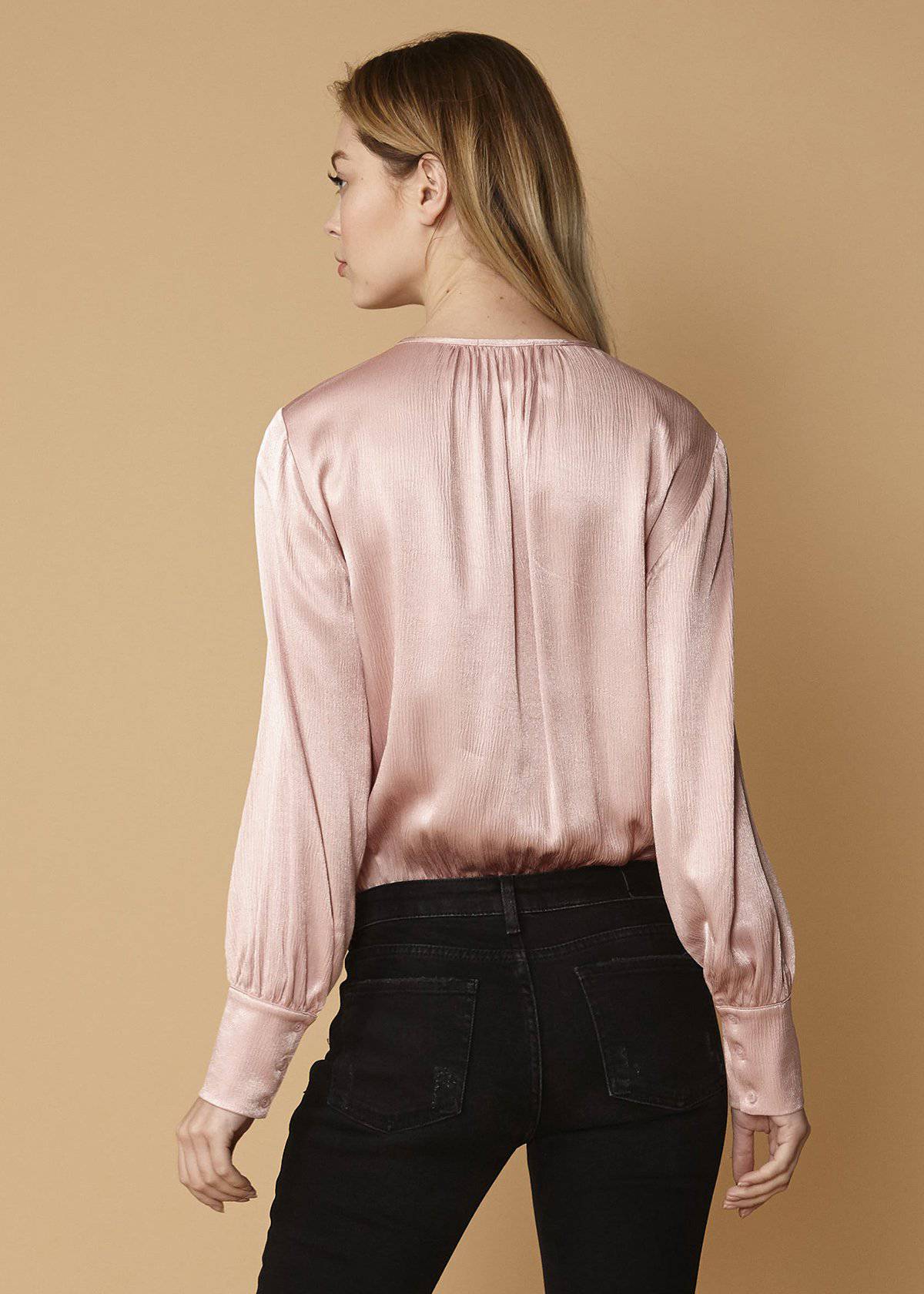 Lemon Hera fall pink tie-neck long sleeve bodysuit with fitted design and button closure, displayed on a hanger.