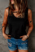 Black strappy hollow-out neck tank top from Harlequin Daisy, displayed on a hanger with a simple background.