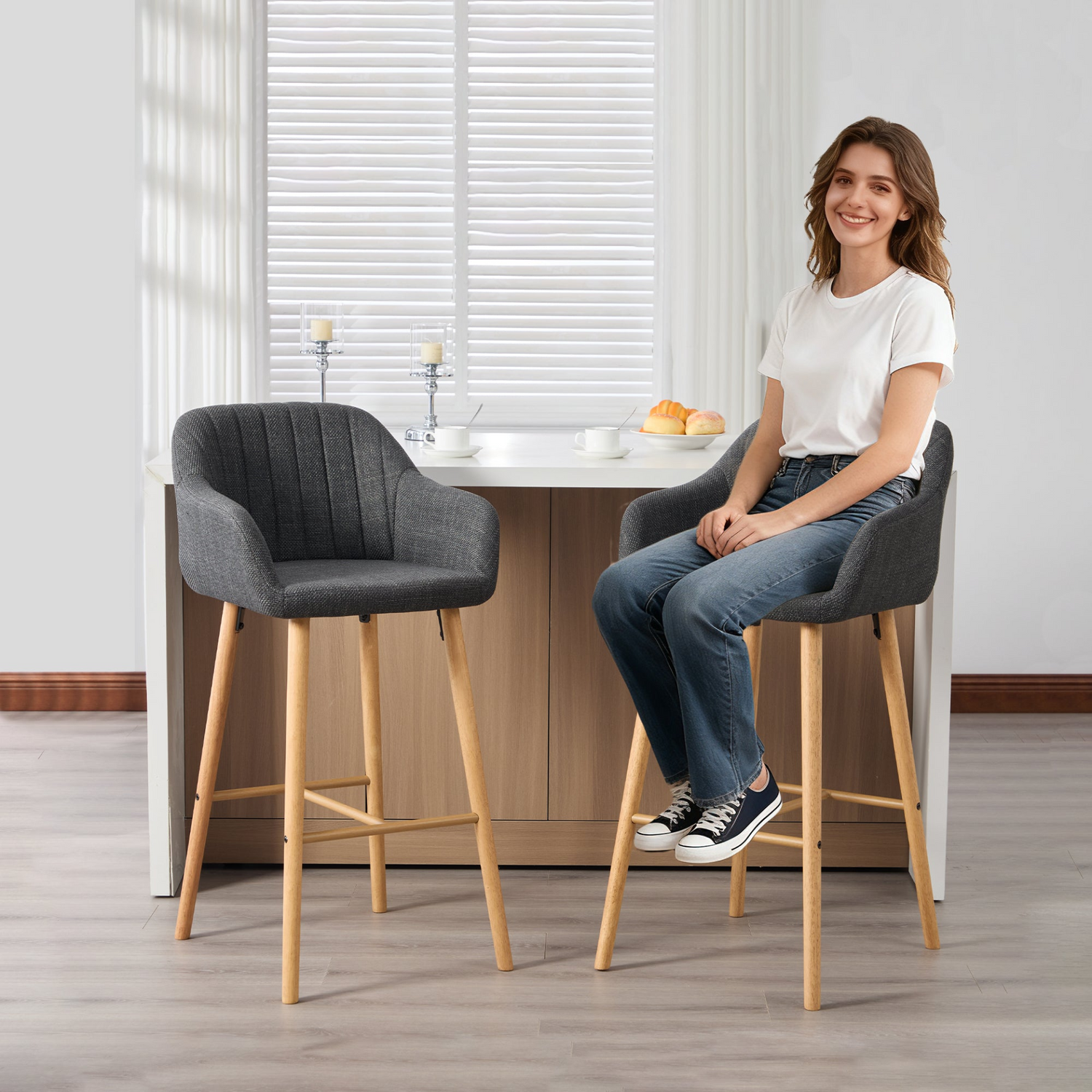 Modern linen upholstered bar stool by Start2Finish with back, armrests, footrest, and solid wood legs shown from a side angle.