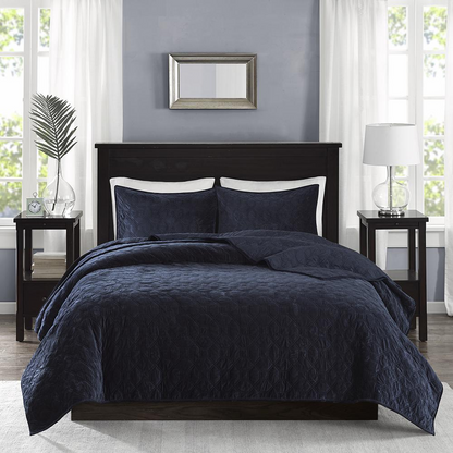 Start2Finish Harper 3-piece navy velvet quilt set with matching pillow shams and decorative pillows on a bed.