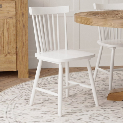 Set of 2 white Lyra side chairs by Start2Finish with sleek modern design, featuring curved backs and wooden legs.
