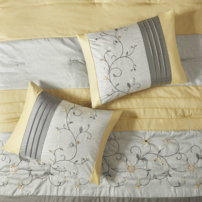 Embroidered 7-piece comforter set by Start2Finish featuring intricate embroidery and coordinating pillow shams on a bed.