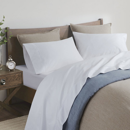 Start2Finish Pima Cotton Sheet Set with smooth, white sheets and pillowcases draped over a bed for comfortable bedding.