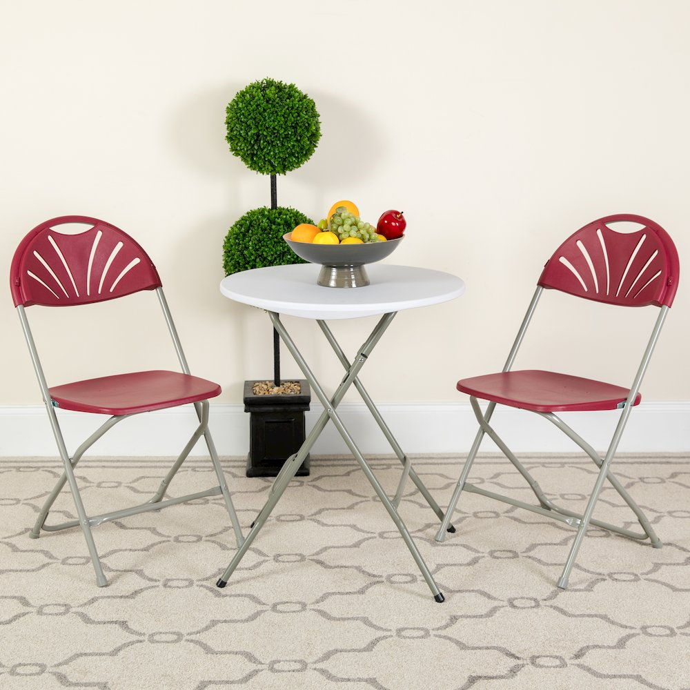 Two burgundy plastic fan back folding chairs with sturdy frames and metal legs, part of the HERCULES Series with 650 lb. capacity.