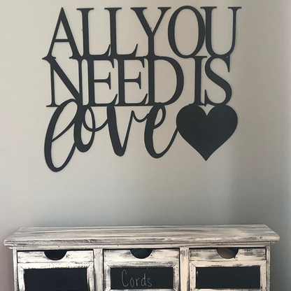 Malachite metal wall art featuring "All You Need Is Love" design hanging above a dresser in home decor style.