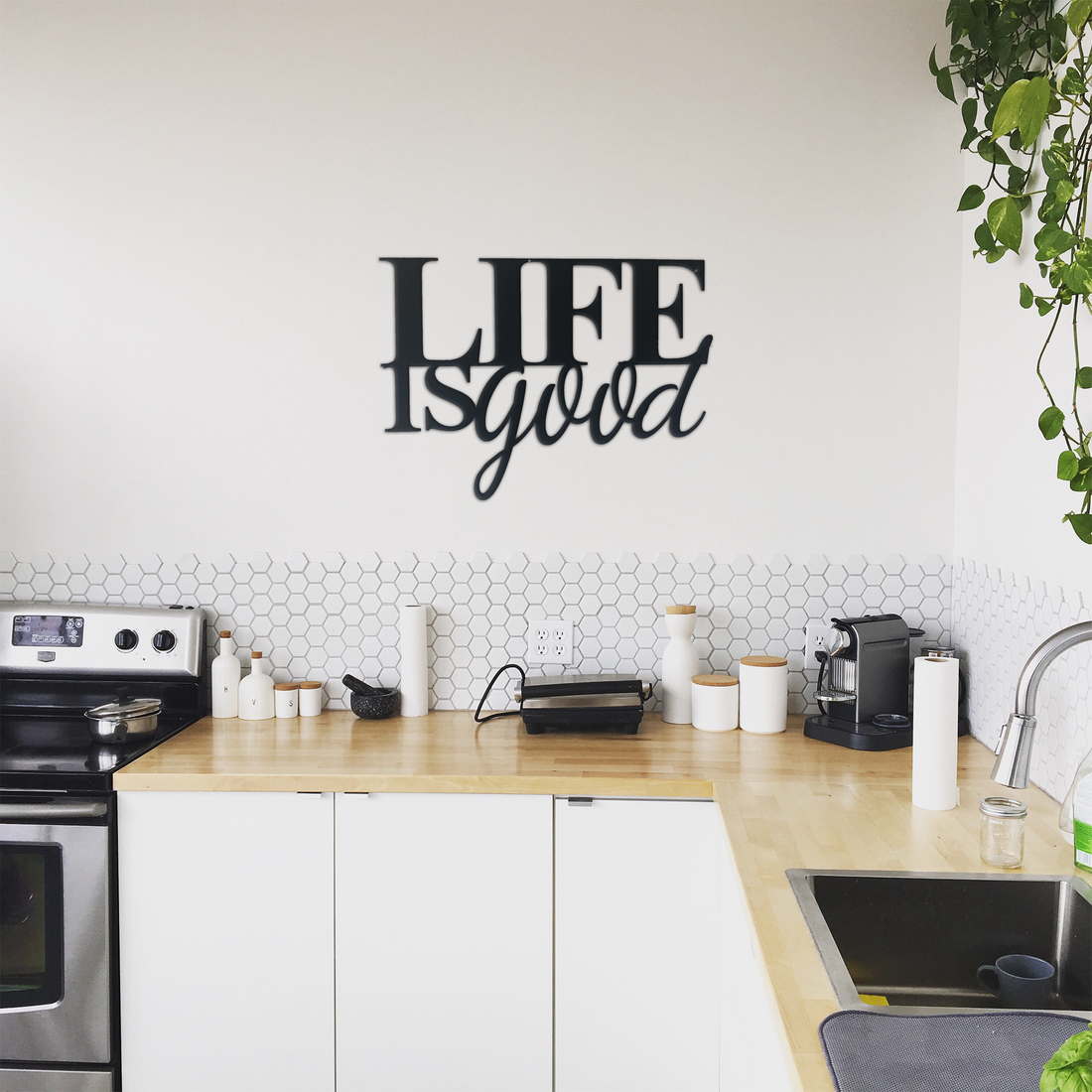 Malachite Life is Good metal wall art displayed in a kitchen setting, showcasing vibrant, decorative home decor with a positive message.
