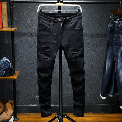 Black ripped stretch jeans for men by Carmine Juneberry, featuring a slim fit and distressed denim style.
