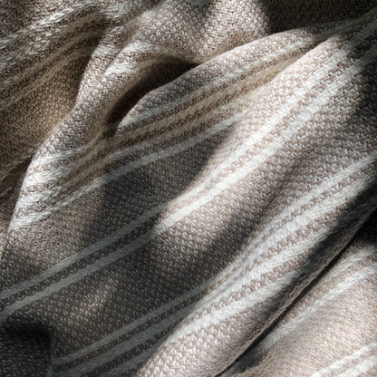 A woven Turkish throw blanket with slate and salt-colored stripes, ideal for home decor, by Ariel.